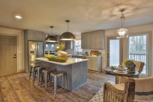 a kitchen with hardwood floors and a center island featuring Forevermark Cabinetry.