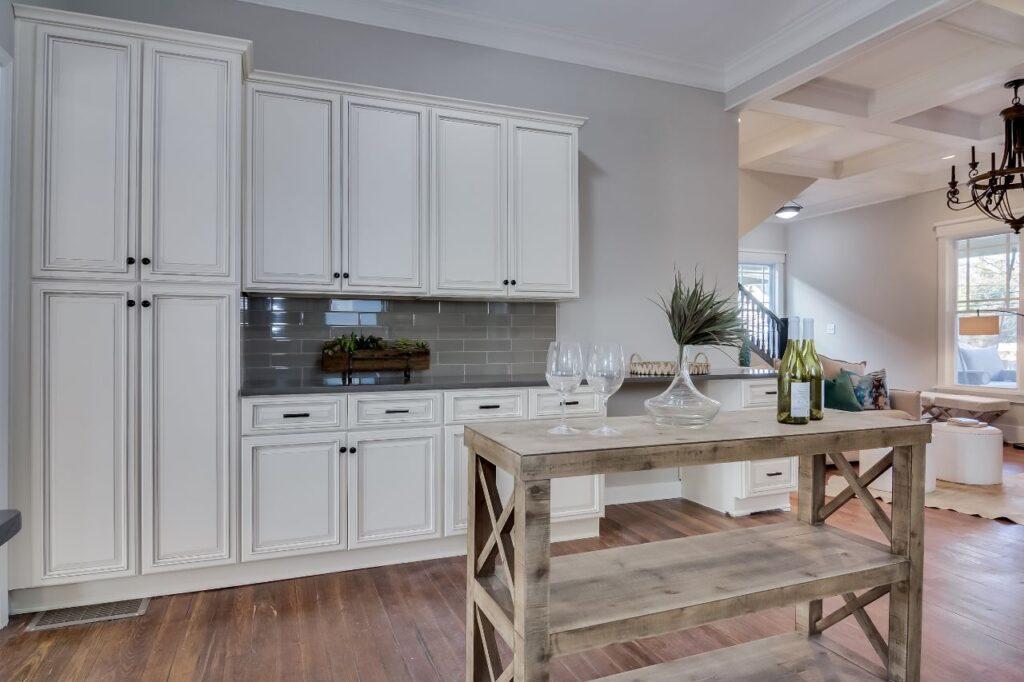 A Forevermark Cabinetry kitchen with white wooden cabinets and a wine rack.