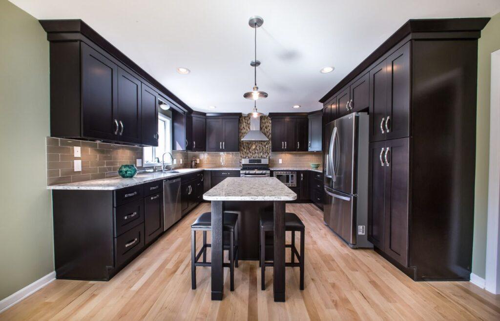 a wood kitchen with Forevermark Cabinetry black kitchen cabinets and a center island.