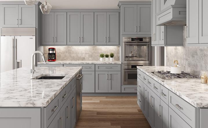 a kitchen with gray Kitchen Cabinets and marble counter tops.