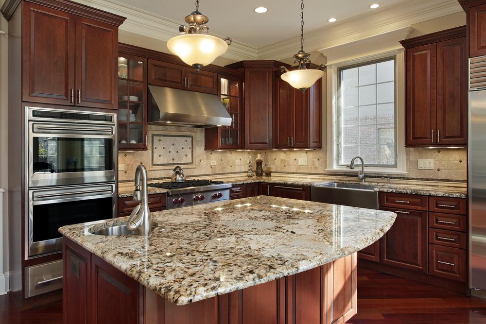 A Forevermark Cabinetry kitchen with brown cabinetry and granite counter tops.