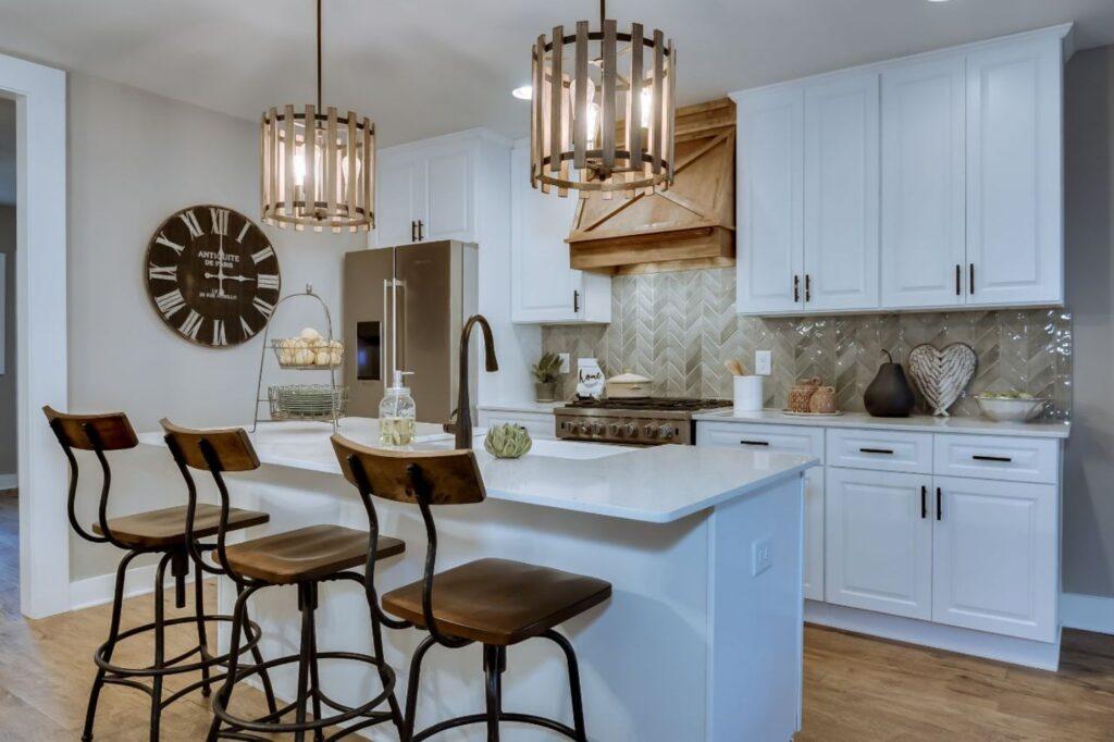 a Forevermark Cabinetry kitchen with white cabinetry and wooden stools.