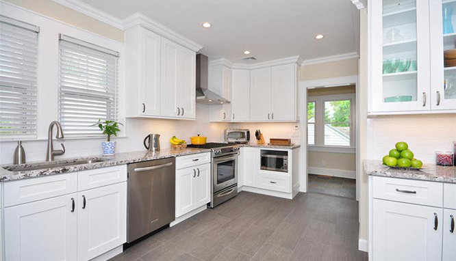 a white kitchen interior with stainless appliances and white wooden cabinets from mykitchencabinets
