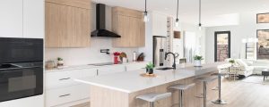 a kitchen with black exhaust hood, white marble island and wooden cabinets by mykitchencabinets