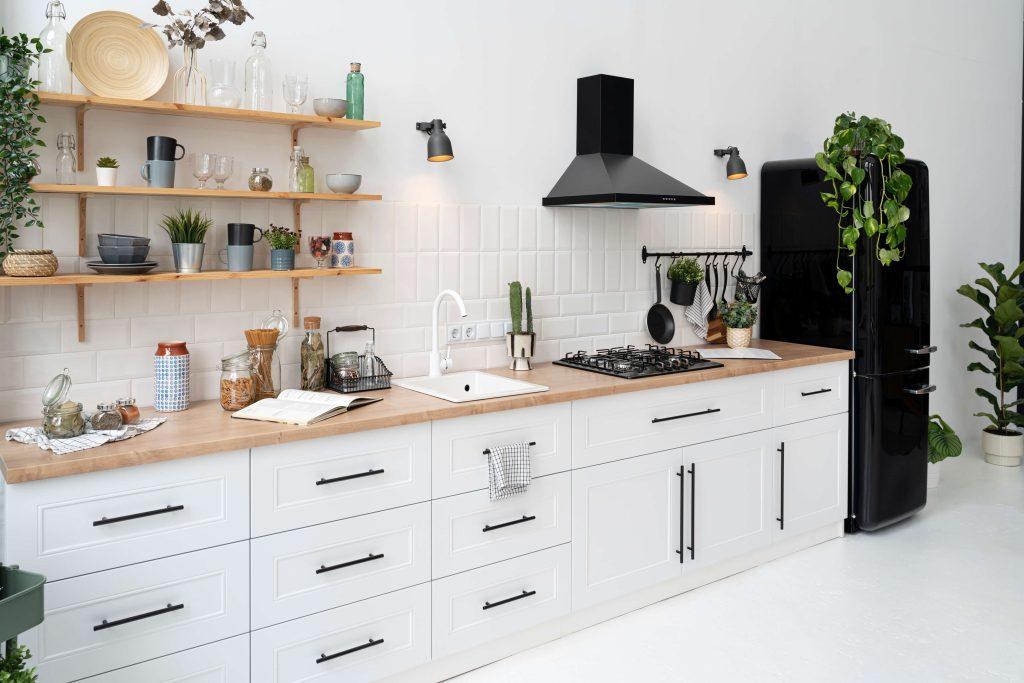 a white kitchen interior with black exhaust hood and white wooden cabinets installed by mykitchencabinets