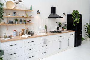 a white kitchen interior with black exhaust hood and white wooden cabinets installed by mykitchencabinets