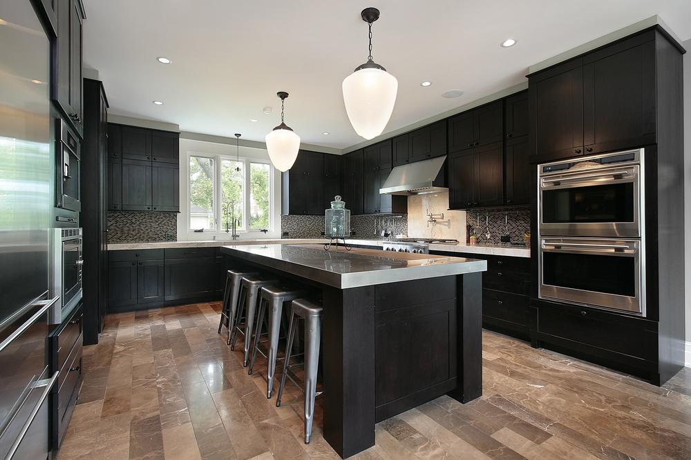 a kitchen with white marble island and black wooden cabinets from mykitchencabinets