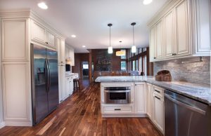 a white kitchen with small white island, and wooden cabinets by mykitchencabinets
