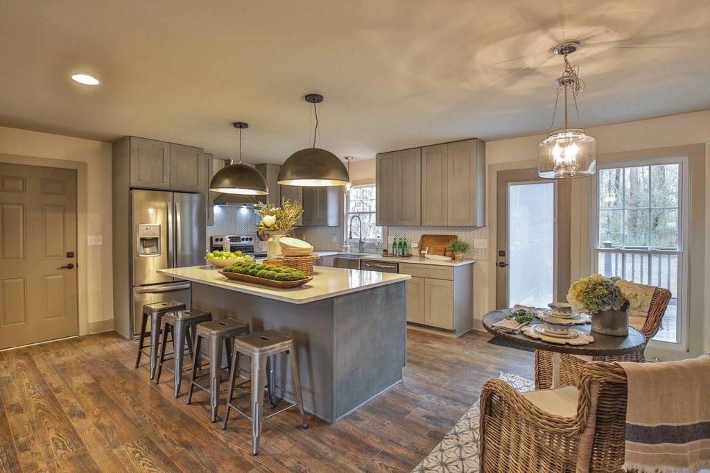 a wooden kitchen flooring with marble island and wooden cabinets from mykitchencabinets