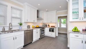 a white kitchen interior with marble sink and wooden kitchen cabinets by mykitchencabinets