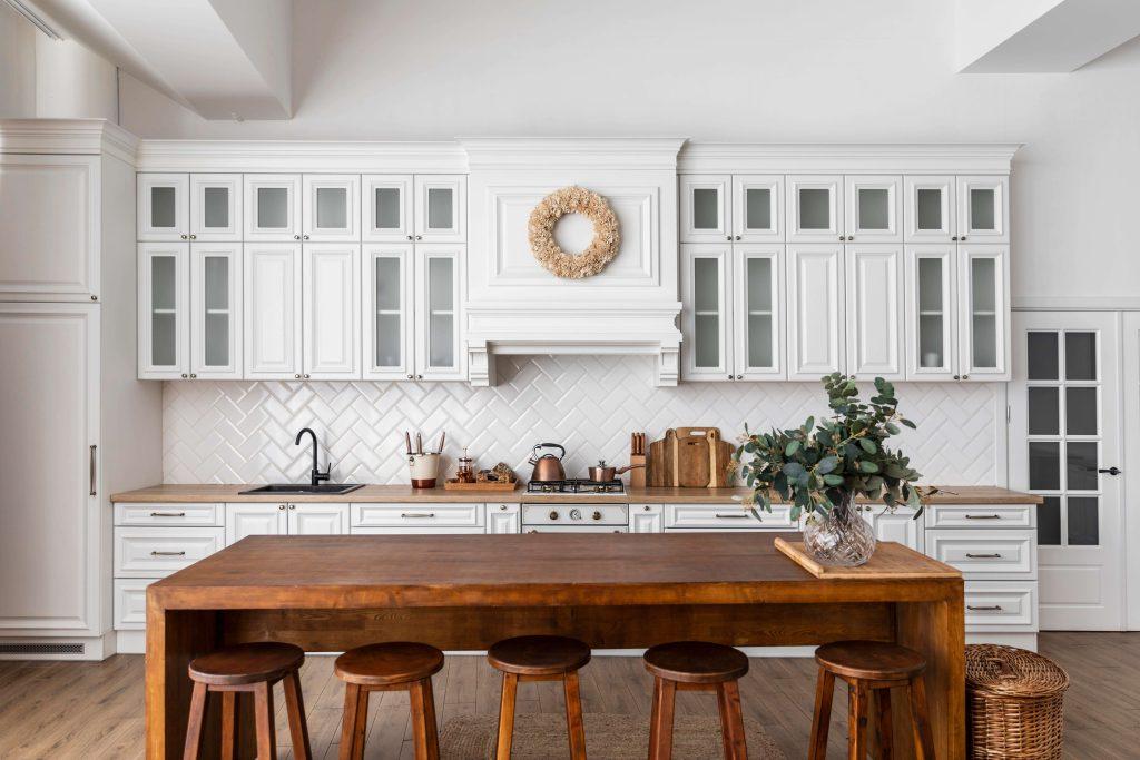 a white kitchen interior with wooden dining set and wooden cabinets from mykitchencabinets